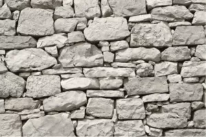 parement-en-pierre-sèche Mur en pierre naturelle claire composé de blocs irréguliers